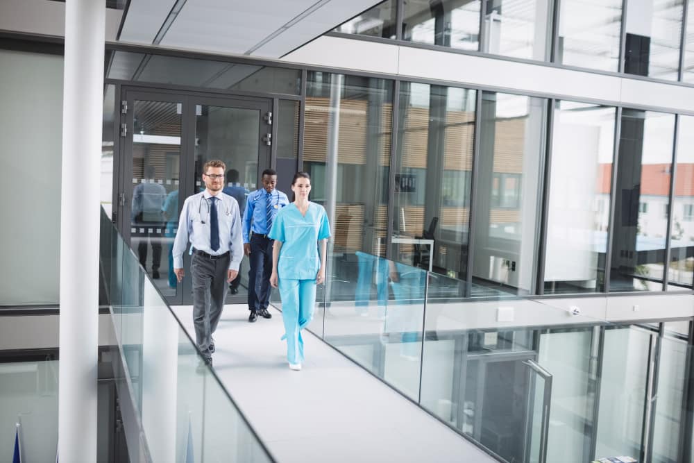 Medical professionals walking in modern Colorado healthcare facility corridor