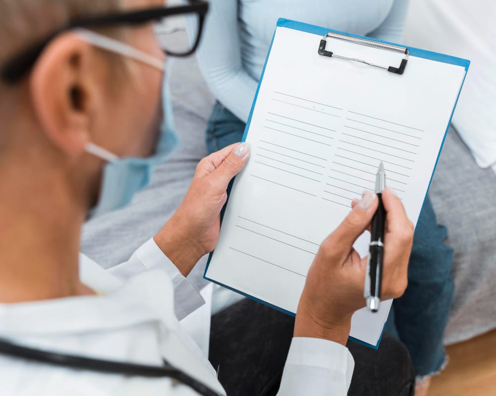 Medical professional completing patient intake clipboard form