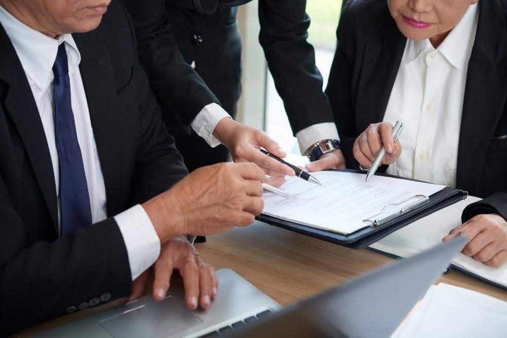 Business professionals reviewing legal documents together at meeting