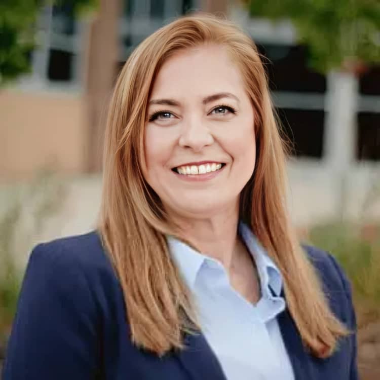 Smiling female attorney in navy blazer standing outside professional building