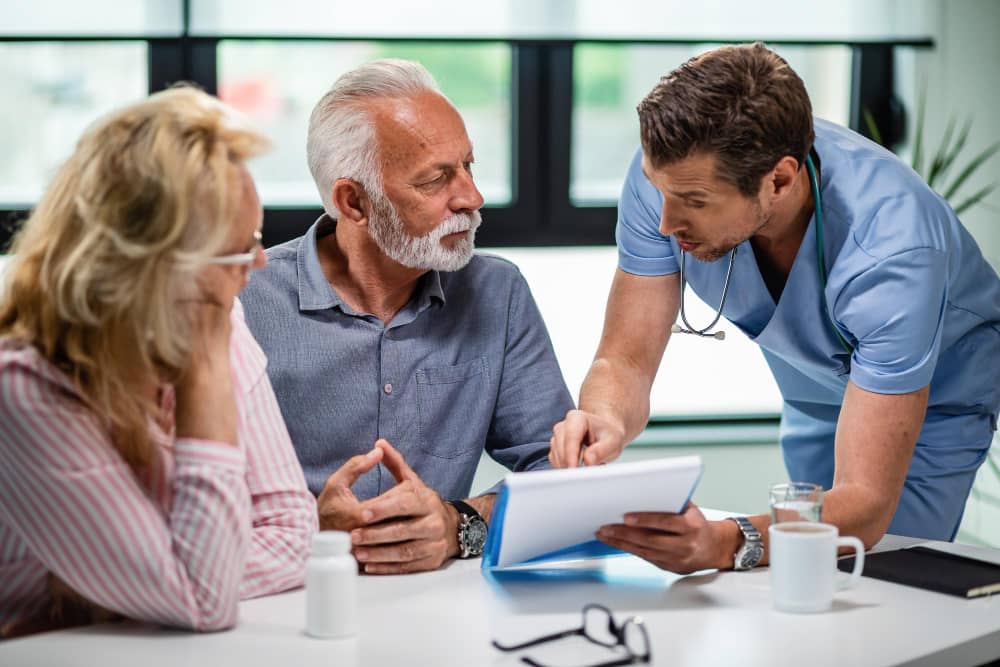 Healthcare provider explaining medical forms to elderly couple