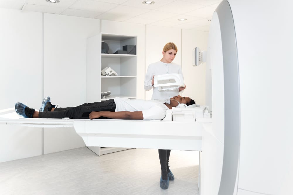 Medical professional operating imaging equipment with patient 